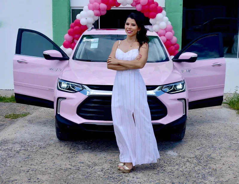 Consultora recebendo o carro rosa Mary Kay com arco de balões